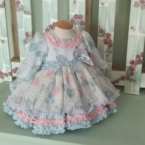 Vestido de niña con volantes estampado floral en tonos rosa y celeste con lazo delantero